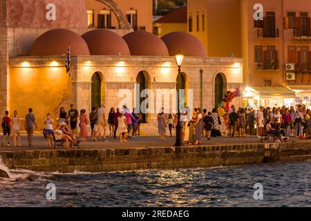 KRETA, GRIECHENLAND - JULI 03 2023: Touristenmassen am Abend in der Nähe der alten Moschee am alten venezianischen Hafen von Chania auf der Insel Kreta Stockfoto