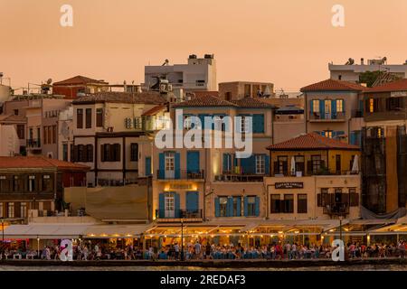 KRETA, GRIECHENLAND - JULI 03 2023: Abends treffen sich viele Touristen in Restaurants rund um den alten venezianischen Hafen von Chania im Westen Kretas Stockfoto