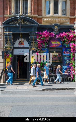 Leute, die in der St. Martins Lane spazieren gehen, kommen am farbenfrohen Theatre Cafe vorbei, einem Theater-Café in Covent Garden, London, England, Großbritannien Stockfoto