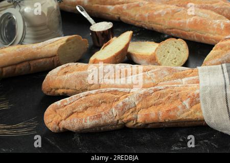 Frische französische Baguettes mit dunkelschwarzem Marmorhintergrund. Seitenansicht. Stockfoto