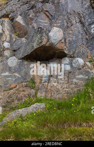 Faces, Rock Art Carvings, Teil des Stone & man-Projekts des lokalen Künstlers alias Høegh auf Qaqortoq, Grönland im Juli Stockfoto