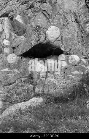 Faces, Rock Art Carvings, Teil des Stone & man-Projekts des lokalen Künstlers alias Høegh auf Qaqortoq, Grönland im Juli - monochrom, schwarz und weiß Stockfoto