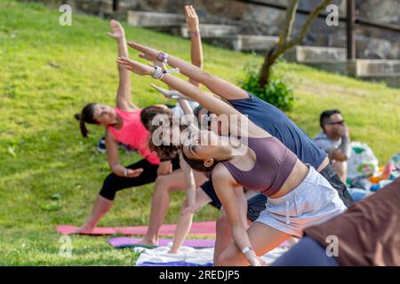 AMEIXIAL, PORTUGAL - 29. April 2023: Gruppe, die Yoga- und Meditationsübungen in einem Garten durchführt. Stockfoto