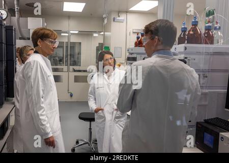 Mainz, Deutschland. 27. Juli 2023. Bundesforschungsministerin Bettina stark-Watzinger (l) und Daniela Schmitt (M), Wirtschaftsministerin von Rheinland-Pfalz, stehen in einer Abteilung, in der die Qualitätssicherung mRNA-basierter Therapien in der Krebsbehandlung bei ihrem Besuch beim Mainzer Impfstoffhersteller BioNTech überprüft wird. Kredit: Helmut Fricke/dpa/Alamy Live News Stockfoto