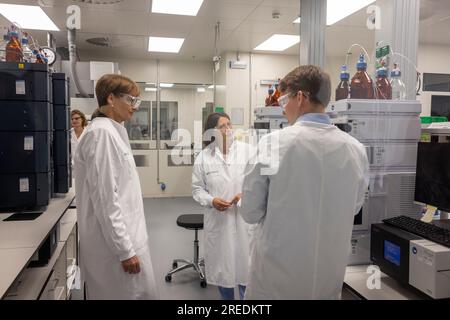 Mainz, Deutschland. 27. Juli 2023. Bundesforschungsministerin Bettina stark-Watzinger (l) und Daniela Schmitt (M), Wirtschaftsministerin von Rheinland-Pfalz, stehen in einer Abteilung, in der die Qualitätssicherung mRNA-basierter Therapien in der Krebsbehandlung bei ihrem Besuch beim Mainzer Impfstoffhersteller BioNTech überprüft wird. Kredit: Helmut Fricke/dpa/Alamy Live News Stockfoto