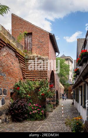 Die alte nordwestliche Stadtmauer an der Mauer Straße in Zons am Rhein, im Hintergrund der Mautturm Nordrhein-Westfalen, Deutschland die alte noerd Stockfoto