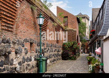 Die alte nordwestliche Stadtmauer an der Mauer Straße in Zons am Rhein, im Hintergrund der Mautturm Nordrhein-Westfalen, Deutschland die alte noerd Stockfoto