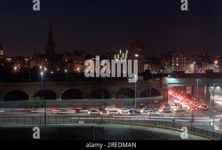 Nachtverkehr mit Autolichtpfaden auf einer Straße im Stadtzentrum von Manchester Stockfoto