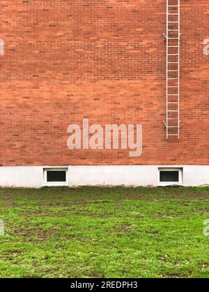 Sicherheitsleitern an Ziegelmauern Stockfoto