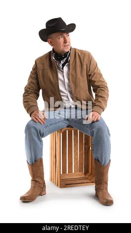 Reifer Cowboy, der auf weißem Hintergrund sitzt Stockfoto