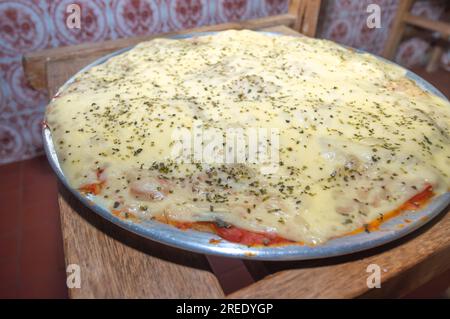 Pizza mit Kartoffelteig, Mangerican Käse und Oregano, Tageslicht, hausgemachte Pizza, einfaches Küchenkonzept. Stockfoto