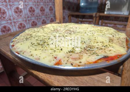 Pizza mit Kartoffelteig, Mangerican Käse und Oregano, Tageslicht, hausgemachte Pizza, einfaches Küchenkonzept. Stockfoto