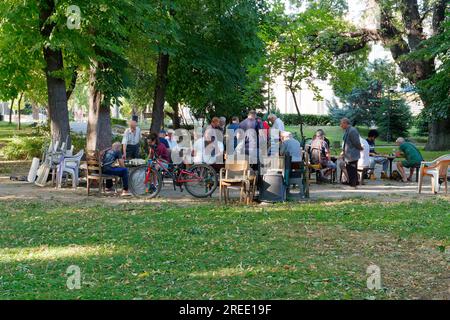 Menschen, die sich treffen und Schach spielen, an einem Sommerabend in einem Park im Zentrum von Plovdiw, Bulgarien Stockfoto