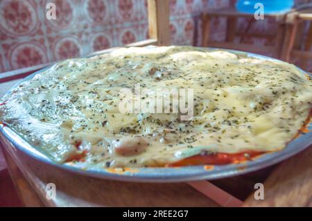 Pizza mit Kartoffelteig, Mangerican Käse und Oregano, Tageslicht, hausgemachte Pizza, einfaches Küchenkonzept. Stockfoto