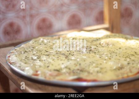 Pizza mit Kartoffelteig, Mangerican Käse und Oregano, Tageslicht, hausgemachte Pizza, einfaches Küchenkonzept. Stockfoto