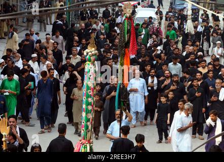 Anhänger von Imam Hussain (A.S.) halten in Erinnerung an das Märtyrertum von Hazrat Imam Hussain (AS), Enkel des Propheten Mohammad (PBUH), im Zusammenhang mit 8. Muharram-ul-Haram am am Donnerstag, den 27. Juli 2023 in Qissa Khuwani Bazar in Peshawar eine religiöse Trauerprozession ab. Stockfoto