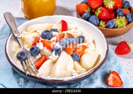 Hausgemachter Hüttenkäse gekochte Gnocchi mit Beeren, faule Teigtaschen Vareniki mit frischen Erdbeeren und Heidelbeeren Stockfoto