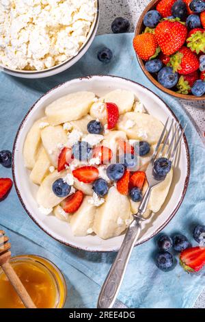 Hausgemachter Hüttenkäse gekochte Gnocchi mit Beeren, faule Teigtaschen Vareniki mit frischen Erdbeeren und Heidelbeeren Stockfoto