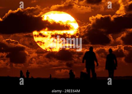 Isle Of Palms, Usa. 27. Juli 2023. Strandbesucher, die vom Sonnenaufgang über dem Atlantischen Ozean am Strand abgeschirmt wurden, 27. Juli 2023 auf der Isle of Palms, South Carolina. Eine anhaltende Hitzewelle über den Süden der USA bringt weiterhin extrem heißes, feuchtes Wetter in die Region. Kredit: Richard Ellis/Richard Ellis/Alamy Live News Stockfoto