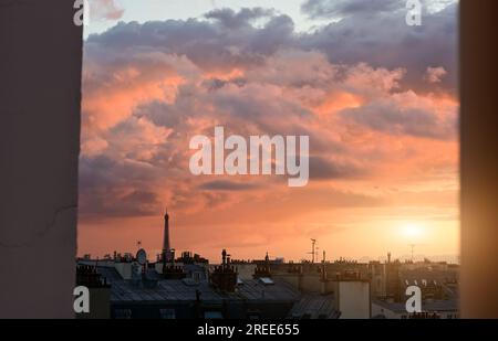 Paris, Frankreich, Juni 2022. Faszinierender Sonnenuntergang über der Stadt. Der Eiffelturm, der sich unter den Dächern der historischen Häuser auszeichnet, ist wiederzuerkennen Stockfoto