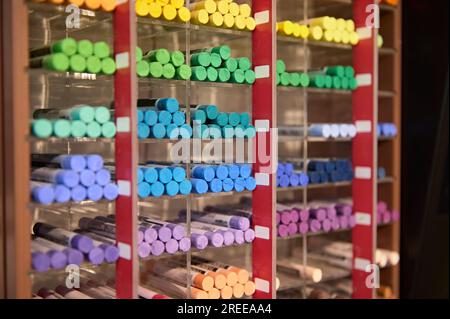 Ein Regal mit bunten Pastellstiften in leuchtenden Farben, das im Schreibwarenladen der Schule zum Verkauf angeboten wird. Malerei. Skizzieren. Schattierung. Zeichnen. Werkzeug Stockfoto