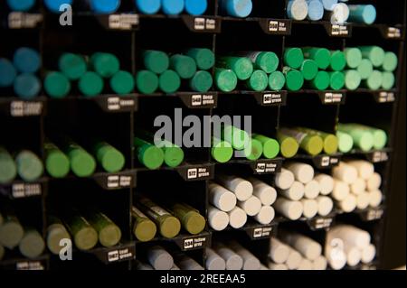 Ein Hintergrund mit Buntstiften in verschiedenen Grüntönen für Pastellmalerei, die in einem kreativen Kunsthandwerk in Regalen zum Verkauf stehen. Zeichnen. Schattierung. Stockfoto