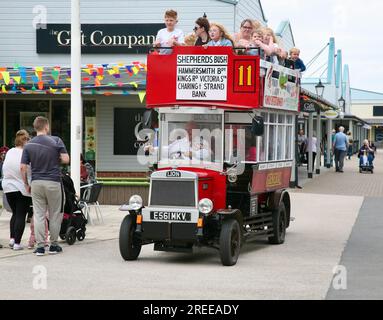 Ein Oldtimer-Bus bringt Urlauber zu einer Spritztour durch die Affinity Shopping Mall im Hafen von Fleetwood, Lancashire, Großbritannien Stockfoto