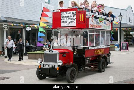 Ein alter Oldtimer-Bus, der junge Familienmitglieder zu einer Spritztour durch die Affinity Shopping Mall im Hafen von Fleetwood, Lancashire, Großbritannien, bringt Europa Stockfoto