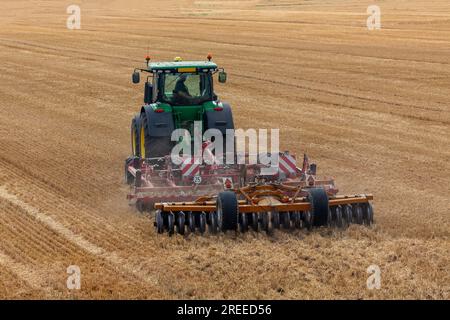 Sommerlandwirtschaft im Süden Englands. Rückansicht des Traktors und des Pflugs beim Wegfahren. Stockfoto