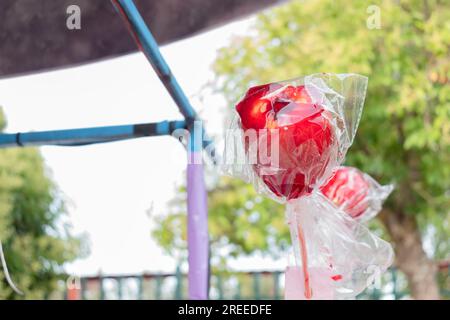 Roter Süßigkeitenapfel, in Plastik eingewickelt an einem Street Food Stand bei einem Street Festival. Sommerzeit. Stockfoto