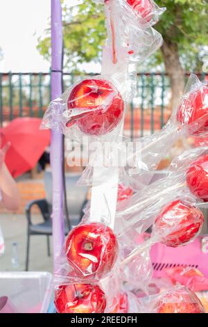 Rote Süßigkeiten-Äpfel in Plastik verpackt an einem Street Food Stand bei einem Street Festival. Sommerzeit. Stockfoto