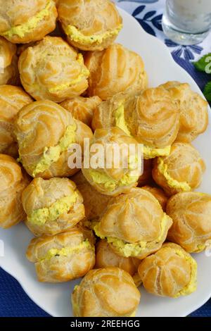 Schwäbische Küche, Mini-Creme-Puffs gefüllt mit Ziegencreme-Käse, Frischkäse-Eclairs, profiterole auf dem Teller, Shortbread, Ofenkuchen Stockfoto