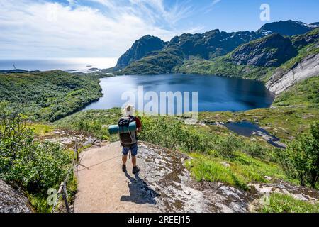 Bergsteiger auf dem Wanderweg zur Munkebu-Hütte, Blick auf den See Stuvdalsvatnet, Moskenesoya, Lofoten, Nordland, Norwegen Stockfoto