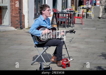 Straßenmusik-Gitarre. Straßenfahrer, der eine Stahlgitarre spielt und in Stratford-upon-Avon, England, singt Stockfoto
