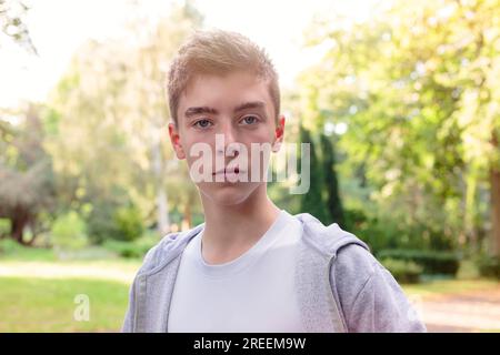 Porträt eines wunderschönen jungen Mannes, der in einer sonnenverwaschenen Landschaft steht Stockfoto