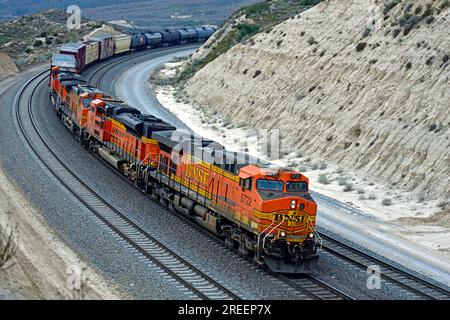 BNSF Manifest Freight Train nähert sich dem Gipfel des Cajon Pass nahe Silverwood California. Der Zug fährt nach Barstow und nach Osten. Stockfoto
