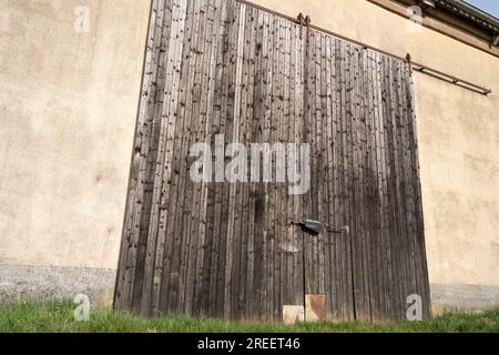 Große alte Holztür einer alten Scheune auf dem Ackerland Stockfoto