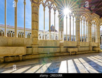 Sonnenschein in Arkaden mit gotischen Tracerys, dem monumentalen Friedhof Camposanto Monumentale, dem Platz des Wunders, der Piazza dei Miracoli und dem Campo dei Miracoli Stockfoto