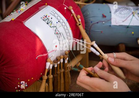 Handwerkerhände, die Spulenstickereien machen - Volkskunst Stockfoto