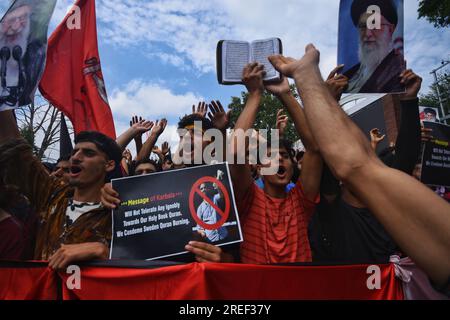 SRINAGAR, JAMMU UND KASCHMIR, INDIEN - 2023/07/27: Kaschmirschiitische Moslems halten Portraits des iranischen Führers und des Korans, die die Verbrennung des islamischen heiligen Korans in Schweden während einer Prozession am 8. Tag Muharram verurteilen. Nach einem Verbot von 34 Jahren durften Muharram-Prozessionen in Srinagar eine traditionelle Route passieren. Muharram ist der erste Monat des islamischen Kalenders. Es ist einer der heiligsten Monate im islamischen Kalender. Schiitische Moslems gedenken Muharram als einen Monat der Trauer zum Gedenken an das Märtyrertum des islamischen Propheten Muhammads Enkel Imam Huss Stockfoto