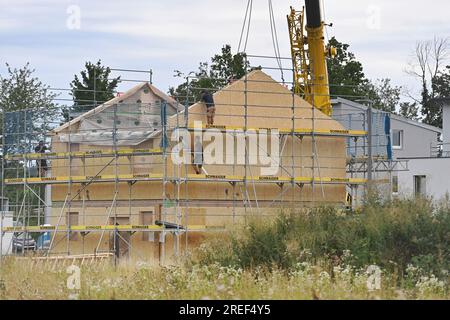 Allershausen, Deutschland. 27. Juli 2023. Die Arbeiter richten ein vorgefertigtes Gebäude, ein vorgefertigtes Gebäude, vorgefertigte Teile, ein Gebäude, ein Einfamilienhaus, Schale, Gerüste, Baustelle, Neubaustelle, Bauindustrie, Neubau in Bayern. Gebäude, Immobilien, Neubau, Gebäudebereich, Neubau. Wohnungsbau, Mietwohnung, Miete, Bauboom, Miethaus, Baugewerbe, Baugewerbe, Immobilien, Immobilien, Baustelle, Baustelle. ? Kredit: dpa/Alamy Live News Stockfoto