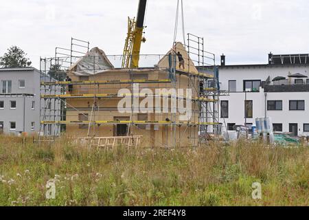 Allershausen, Deutschland. 27. Juli 2023. Die Arbeiter richten ein vorgefertigtes Gebäude, ein vorgefertigtes Gebäude, vorgefertigte Teile, ein Gebäude, ein Einfamilienhaus, Schale, Gerüste, Baustelle, Neubaustelle, Bauindustrie, Neubau in Bayern. Gebäude, Immobilien, Neubau, Gebäudebereich, Neubau. Wohnungsbau, Mietwohnung, Miete, Bauboom, Miethaus, Baugewerbe, Baugewerbe, Immobilien, Immobilien, Baustelle, Baustelle. ? Kredit: dpa/Alamy Live News Stockfoto