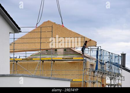Allershausen, Deutschland. 27. Juli 2023. Die Arbeiter richten ein vorgefertigtes Gebäude, ein vorgefertigtes Gebäude, vorgefertigte Teile, ein Gebäude, ein Einfamilienhaus, Schale, Gerüste, Baustelle, Neubaustelle, Bauindustrie, Neubau in Bayern. Gebäude, Immobilien, Neubau, Gebäudebereich, Neubau. Wohnungsbau, Mietwohnung, Miete, Bauboom, Miethaus, Baugewerbe, Baugewerbe, Immobilien, Immobilien, Baustelle, Baustelle. ? Kredit: dpa/Alamy Live News Stockfoto