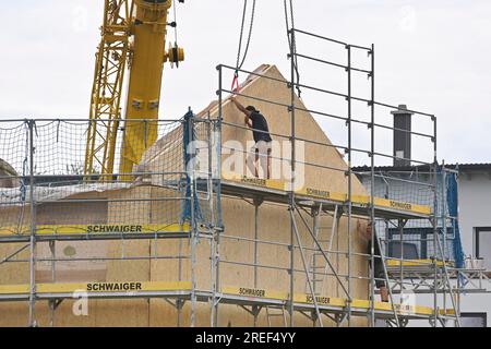 Allershausen, Deutschland. 27. Juli 2023. Die Arbeiter richten ein vorgefertigtes Gebäude, ein vorgefertigtes Gebäude, vorgefertigte Teile, ein Gebäude, ein Einfamilienhaus, Schale, Gerüste, Baustelle, Neubaustelle, Bauindustrie, Neubau in Bayern. Gebäude, Immobilien, Neubau, Gebäudebereich, Neubau. Wohnungsbau, Mietwohnung, Miete, Bauboom, Miethaus, Baugewerbe, Baugewerbe, Immobilien, Immobilien, Baustelle, Baustelle. ? Kredit: dpa/Alamy Live News Stockfoto