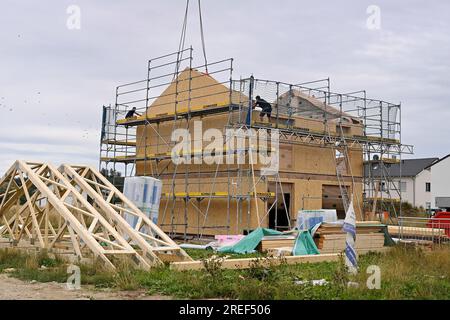 Allershausen, Deutschland. 27. Juli 2023. Die Arbeiter richten ein vorgefertigtes Gebäude, ein vorgefertigtes Gebäude, vorgefertigte Teile, ein Gebäude, ein Einfamilienhaus, Schale, Gerüste, Baustelle, Neubaustelle, Bauindustrie, Neubau in Bayern. Gebäude, Immobilien, Neubau, Gebäudebereich, Neubau. Wohnungsbau, Mietwohnung, Miete, Bauboom, Miethaus, Baugewerbe, Baugewerbe, Immobilien, Immobilien, Baustelle, Baustelle. ? Kredit: dpa/Alamy Live News Stockfoto