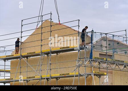 Allershausen, Deutschland. 27. Juli 2023. Die Arbeiter richten ein vorgefertigtes Gebäude, ein vorgefertigtes Gebäude, vorgefertigte Teile, ein Gebäude, ein Einfamilienhaus, Schale, Gerüste, Baustelle, Neubaustelle, Bauindustrie, Neubau in Bayern. Gebäude, Immobilien, Neubau, Gebäudebereich, Neubau. Wohnungsbau, Mietwohnung, Miete, Bauboom, Miethaus, Baugewerbe, Baugewerbe, Immobilien, Immobilien, Baustelle, Baustelle. ? Kredit: dpa/Alamy Live News Stockfoto