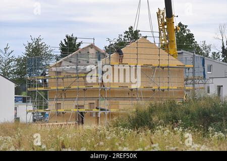 Allershausen, Deutschland. 27. Juli 2023. Die Arbeiter richten ein vorgefertigtes Gebäude, ein vorgefertigtes Gebäude, vorgefertigte Teile, ein Gebäude, ein Einfamilienhaus, Schale, Gerüste, Baustelle, Neubaustelle, Bauindustrie, Neubau in Bayern. Gebäude, Immobilien, Neubau, Gebäudebereich, Neubau. Wohnungsbau, Mietwohnung, Miete, Bauboom, Miethaus, Baugewerbe, Baugewerbe, Immobilien, Immobilien, Baustelle, Baustelle. ? Kredit: dpa/Alamy Live News Stockfoto