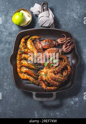 Gegrillte Zuhälter, Tintenfische und Kraken in einer gusseisernen Grillpfanne Stockfoto