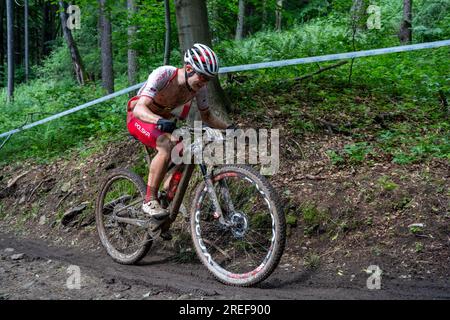 Karol Ostaszewski (Polen) auf rutschigem, schlammigem Hügel - 2023 UEC MTB Elite Europameisterschaft - Europaspiele Krakau - Krynica-Zdrój Stockfoto