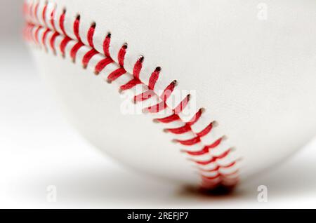 Nahaufnahme eines weißen Baseballballs mit roten Nähten auf weißem Hintergrund Stockfoto